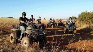 A group of people riding on a vehicle in a field Description automatically generated with low confidence