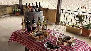 A table with wine bottles and glasses Description automatically generated with low confidence